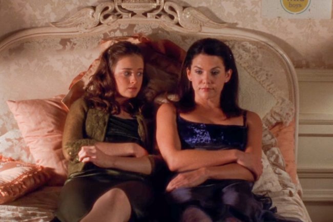 Cena de Gilmore Girls. Mãe e filha estão deitada na cama, tendo alguma conversa séria