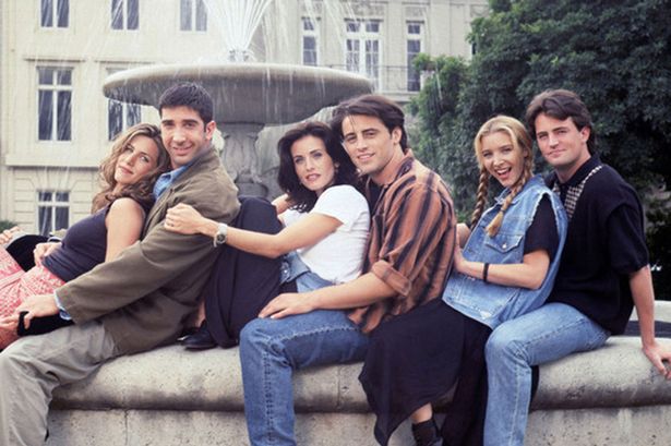 Foto dos seis protagonistas de Friends sentados na beirada de uma fonte de mármore; eles estão alinhados com as costas apoiadas no peito da pessoa que está atrás; em ordem: Rachel, Ross, Monica, Joey, Phoebe e Chandler