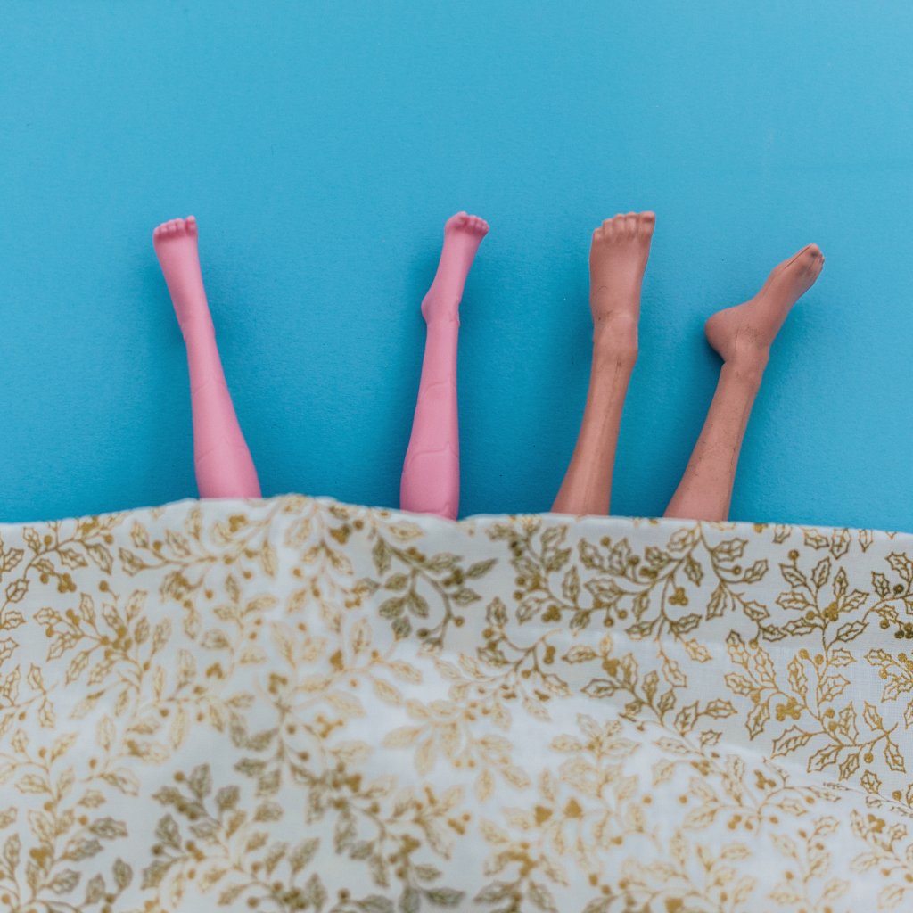 Pernas de boneca em uma cama