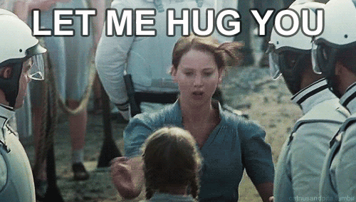 Katniss, de Jogos Vorazes, abraçando uma garotinha