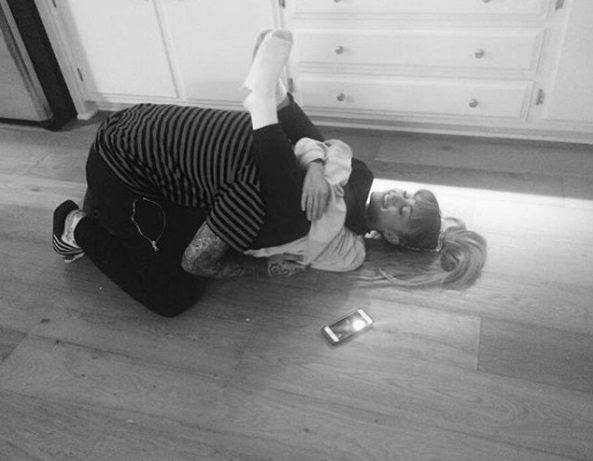 A cantora Ariana Grande está deitada no chão e abraçada com o novo namorado Mac Miller