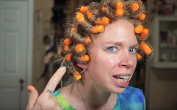 Garota fazendo cachos no cabelo com salgadinho Cheetos