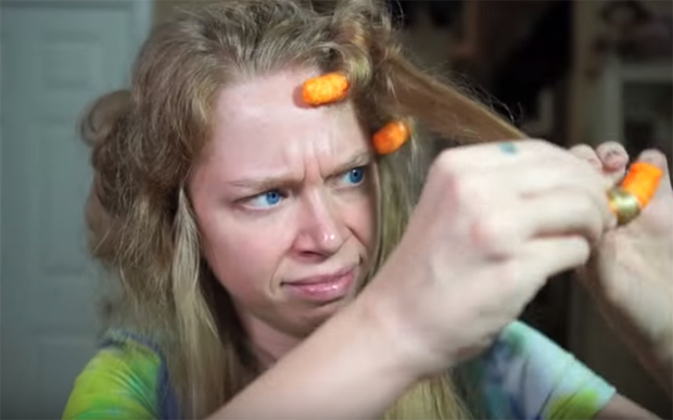 garota fazendo cachos no cabelo com salgadinho Cheetos
