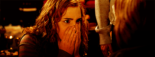 Hermione com a aparência surpresa, levando as mãos até a boca.