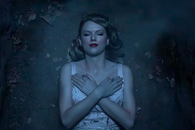 Na sequência, Taylor aparece ~plena~ em um túmulo. A maquiagem é clássica: batom vermelho, pele iluminada e delineador.