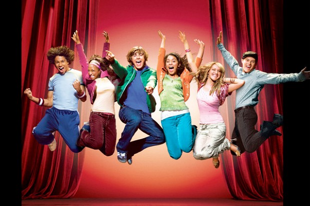 Da esquerda para a direita: Corbin Blue, Monique Coleman, Zac Efron, Vanessa Hudgens, Ashley Tisdale, Lucas Gabreel, todos pulando em frente a uma cortina de teatro