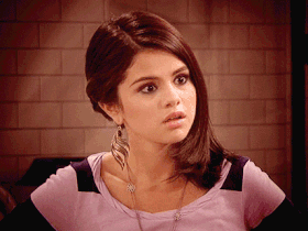 Gif da Selena Gomez fazendo expressão facial de surpresa, abrindo a boca, com as sobrancelhas franzidas.