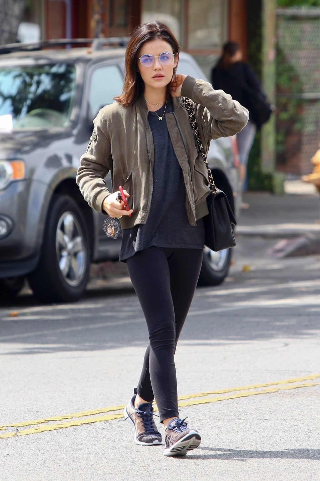 Look da Lucy Hale com jaqueta bomber, legging e tênis.