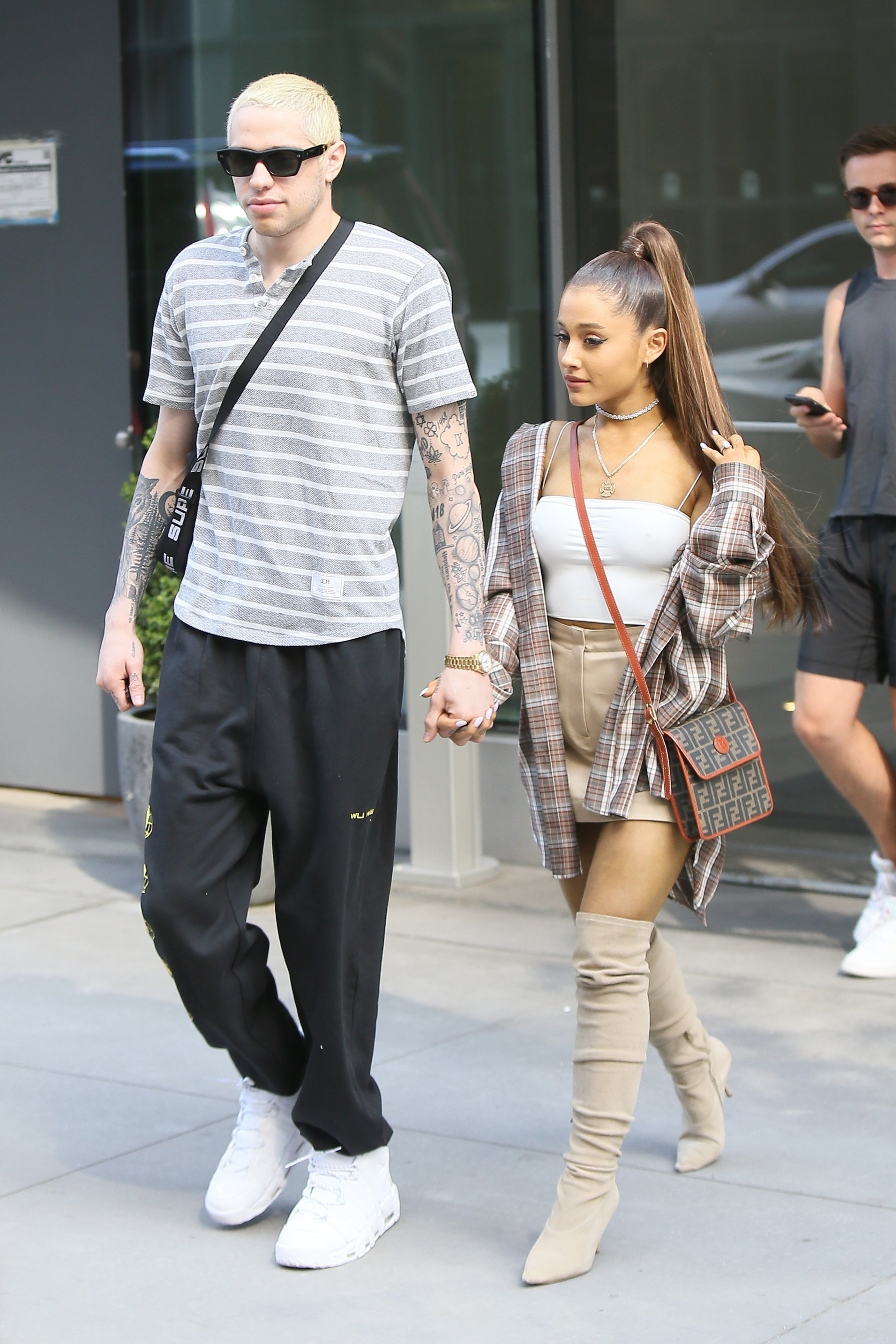 Ariana Grande usando o top brami no street style com minissaia e bota