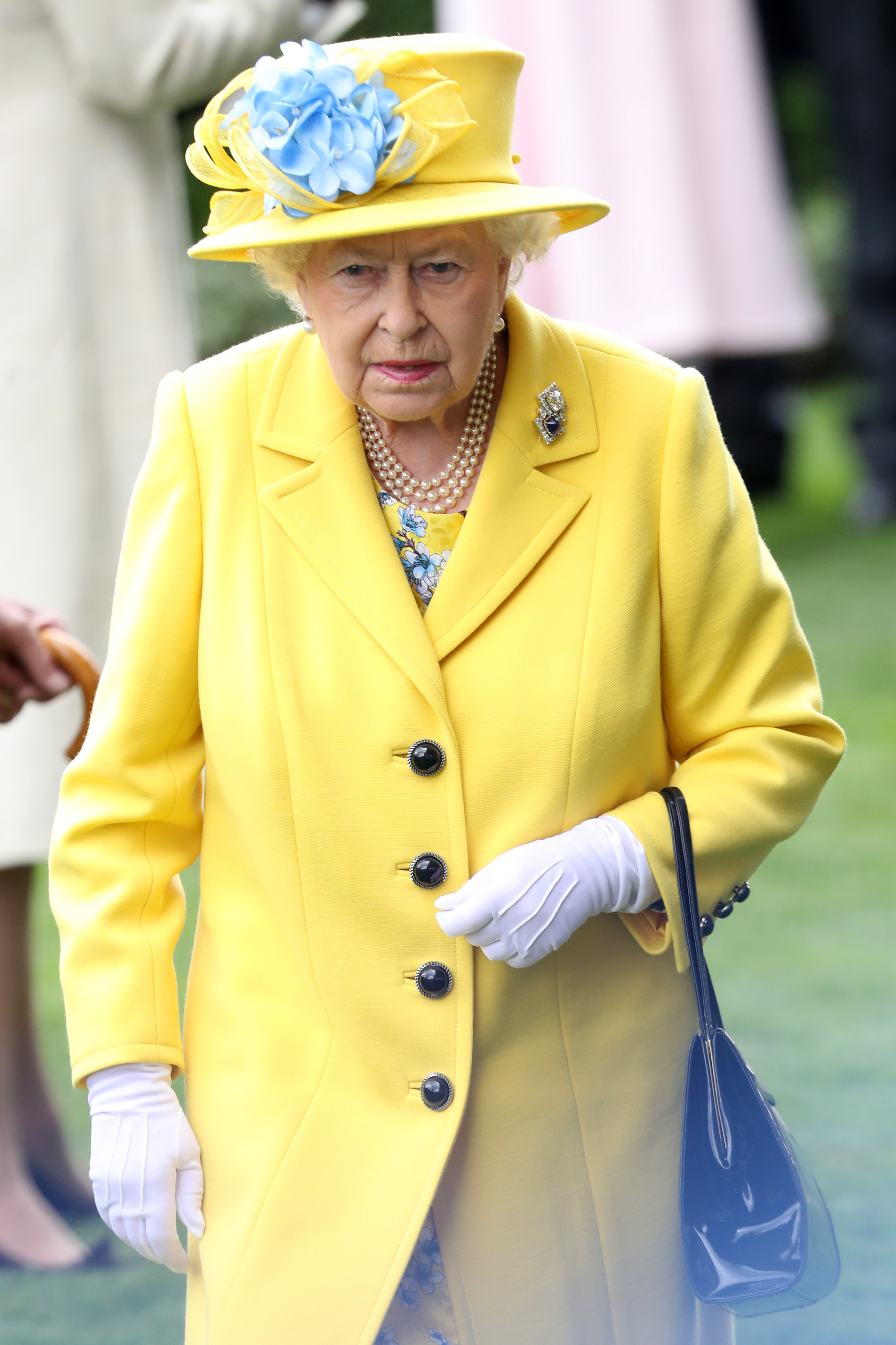 Rainha Elizabeth II usando look amarelo com chapéu