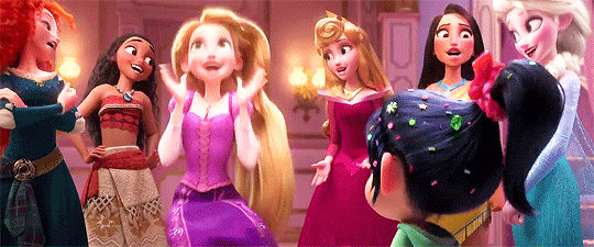 No Gif temos as princesas: Branca de neve, Merida, Aurora, Rapunzel, Pocahontas, Elsa conversando enquanto a rapunzel rodopia. Todas usam suas roupas tradicionais e estão sorridentes.