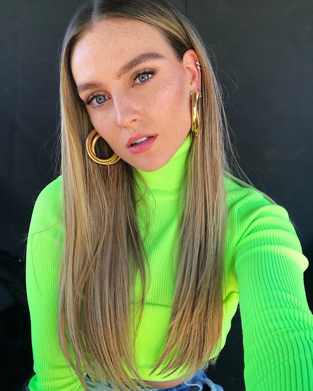 Selfie de Perrie Edwards usando blusa verde limão neon