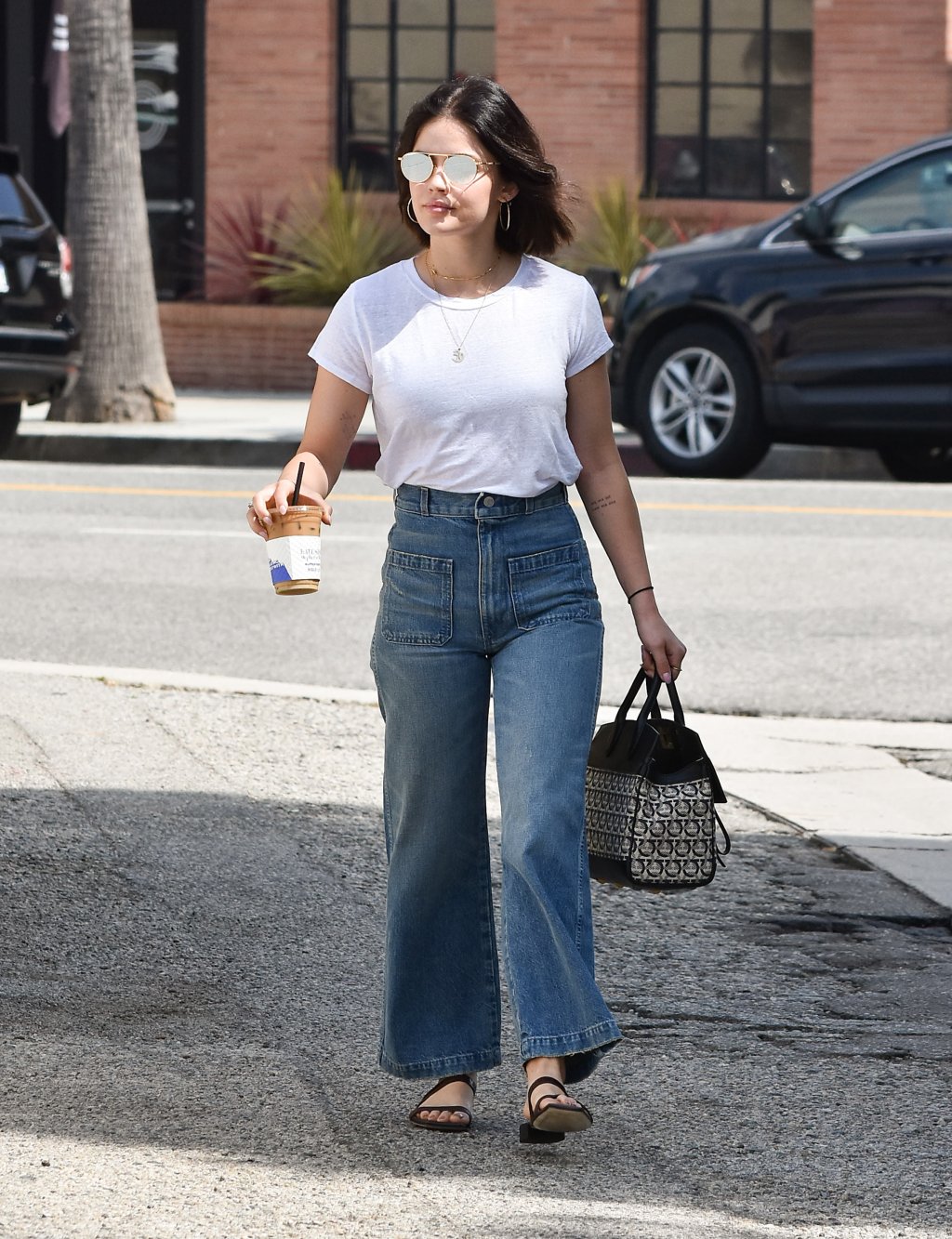 Lucy Hale usando camiseta branca e calça jeans.
