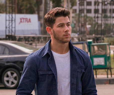 Nick Jonas na rua com jaqueta jeans