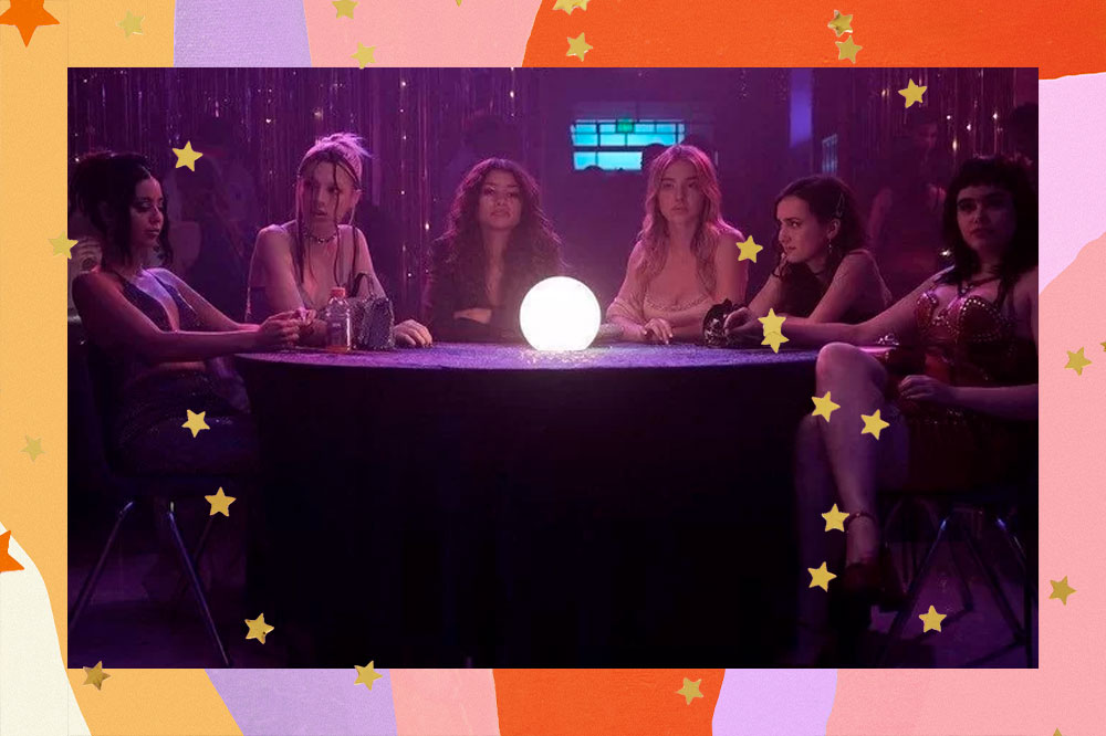 Personagens de Euphoria em cena da primeira temporada; elas estão sentadas em volta de uma mesa redonda iluminada por luzes em tons de rosa e roxo