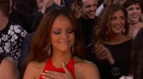 Rihanna batendo palmas em premiação com expressão feliz e surpresa