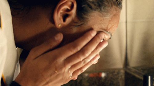 Gif de garota lavando o rosto na frente da pia e passando as mãos pelo rosto