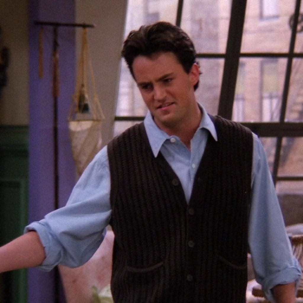 Chandler Bing, personagem de Friends, usando colete de suéter por cima de camisa social