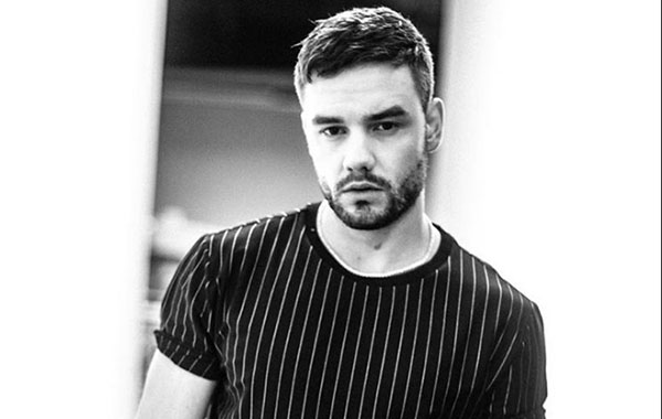 Foto de Liam com blusa listrada e foto está em preto e branco.