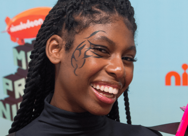 Menina sorri com tatoo na cara
