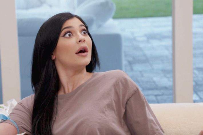 Kylie Jenner com expressão de surpresa e usando uma blusa cinza.