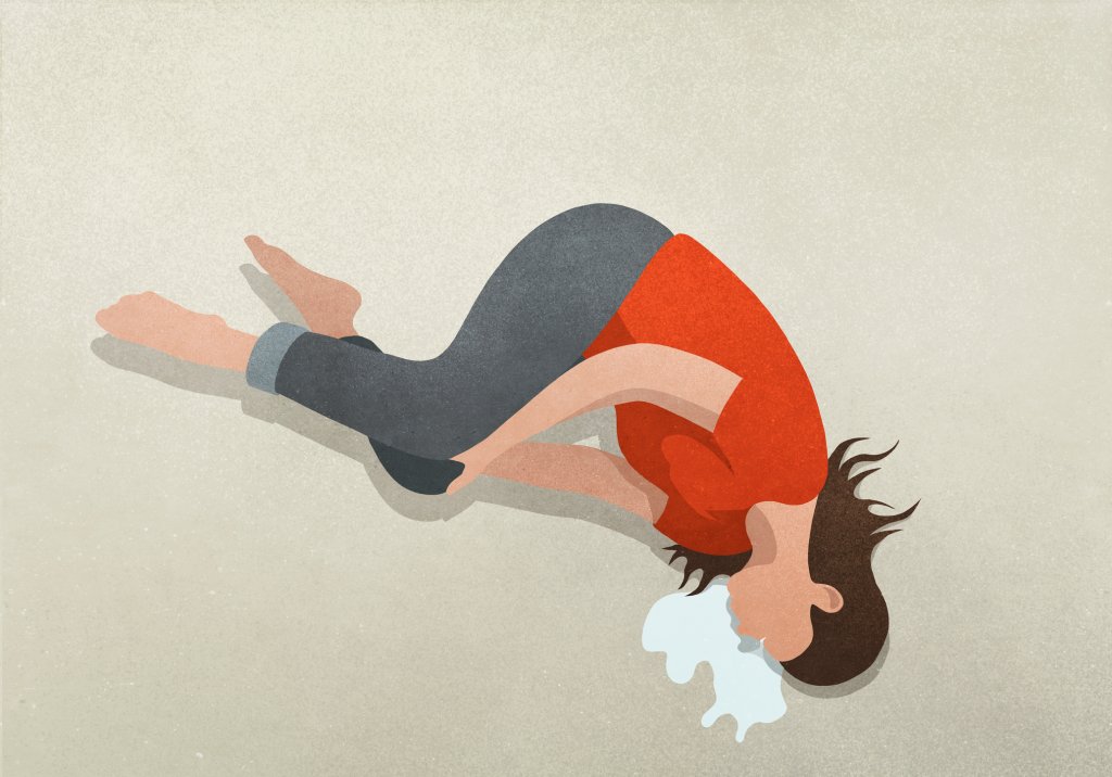 Ilustração de uma mulher deitada em posição fetal no chão, chorando muito. Ela veste uma camiseta vermelha e uma calça preta