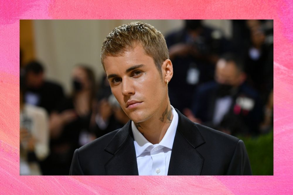 Justin posando para fotos de terno preto e camisa branca no MET Gala.
