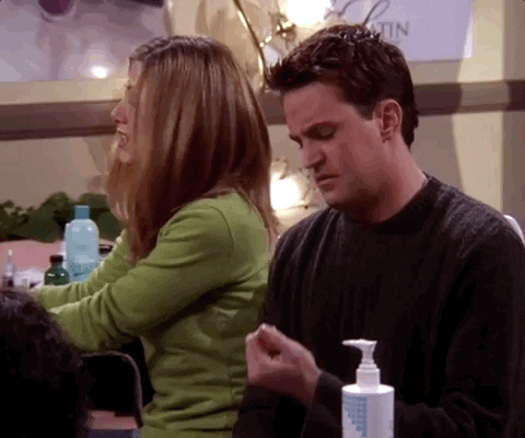 Rachel e Chander do seriado Friends, Rachel está de costas e se vira para olhar chandler assoprar suas unhas recém feitas.