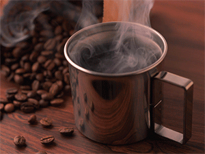 Caneca de metal com café com grãos de café ao fundo