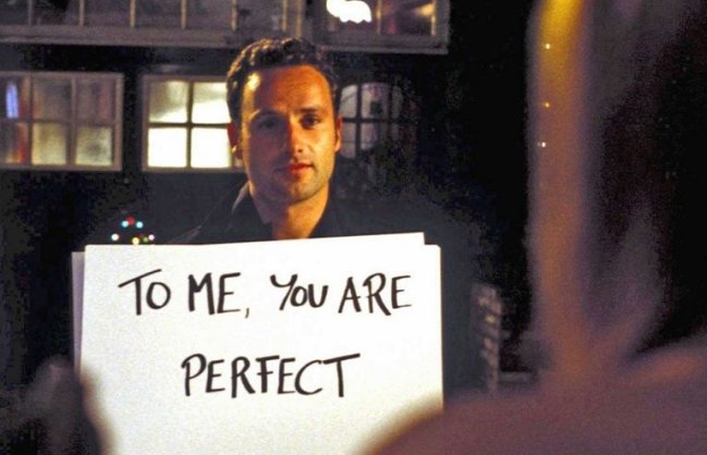 imagem de um homem segurando uma placa com os dizeres: "Para mim, você é perfeita"
