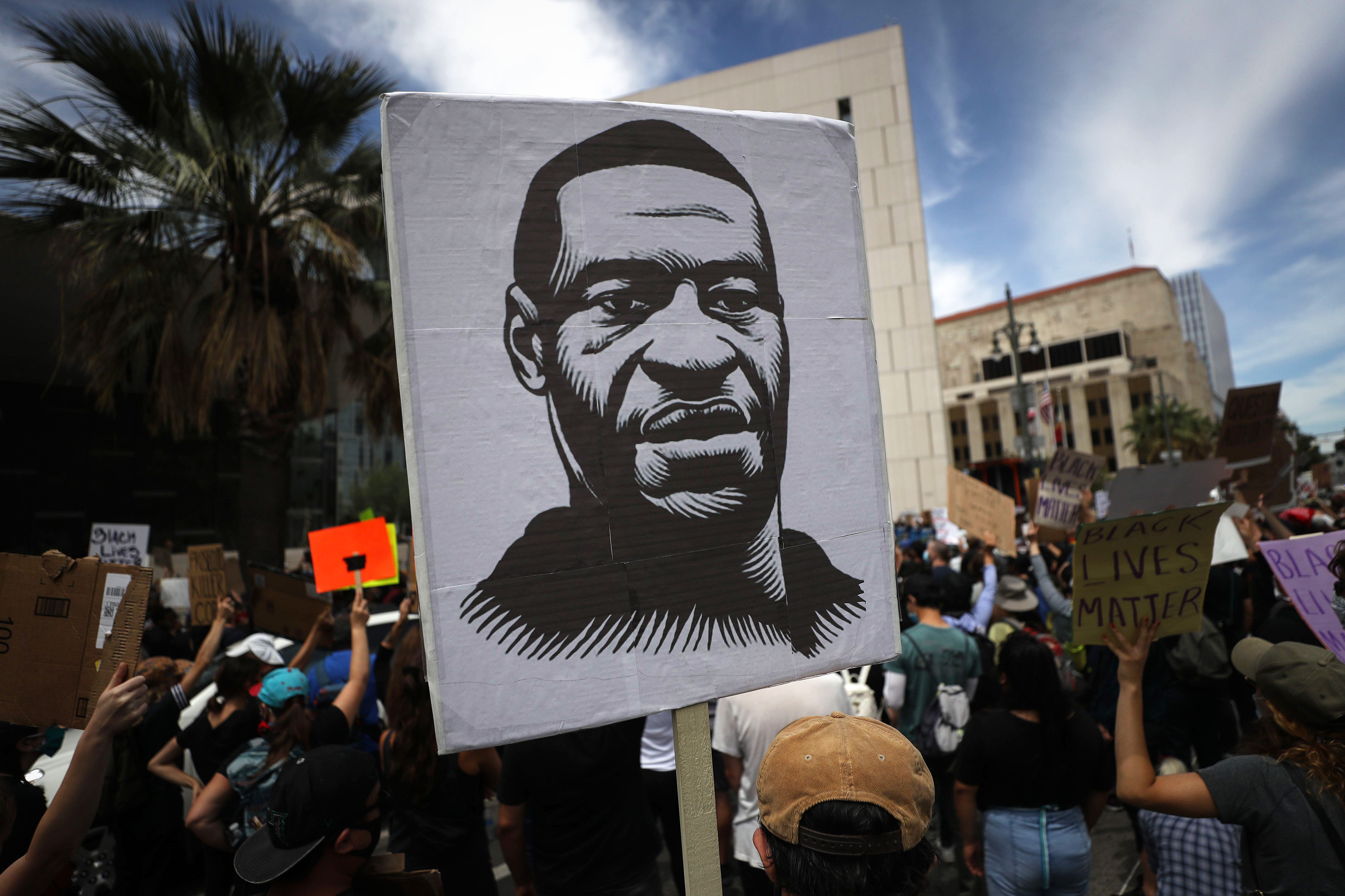 Manifestante segura placa com imagem de George Floyd