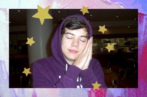 Foto do Harry Styles fingindo que está dormindo, com os olhos fechados e as mãos em concha ao lado do rosto