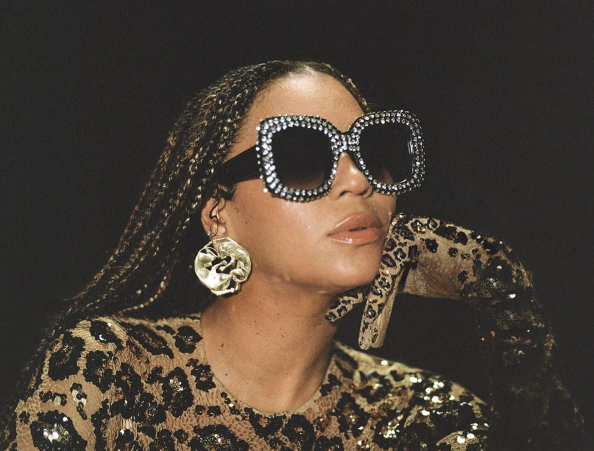 Beyoncé com a mão rosto e óculos escuro