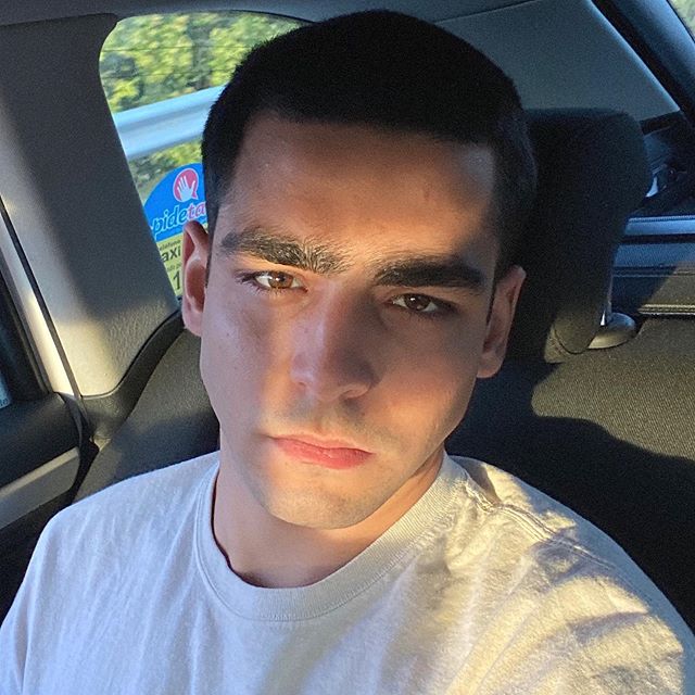 Selfie de Omar com camiseta branca e parte do rosto refletida pelo sol