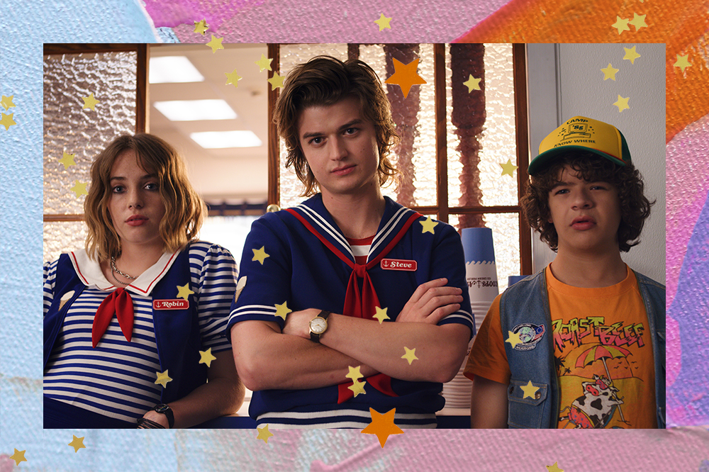 Imagem de Stranger Things, com Robin, Steve e Dustin; os três estão posando para câmera com expressões sérias; a moldura é uma textura em tons de azul, rosa e laranja com estrelas amarelas e laranjas como decoração
