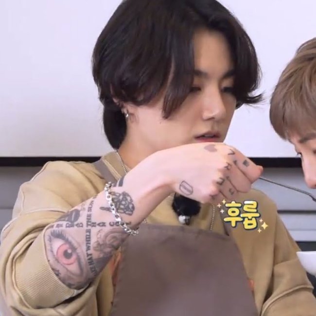 Jungkook durante o programa Run BTS! com as tatuagens a mostra