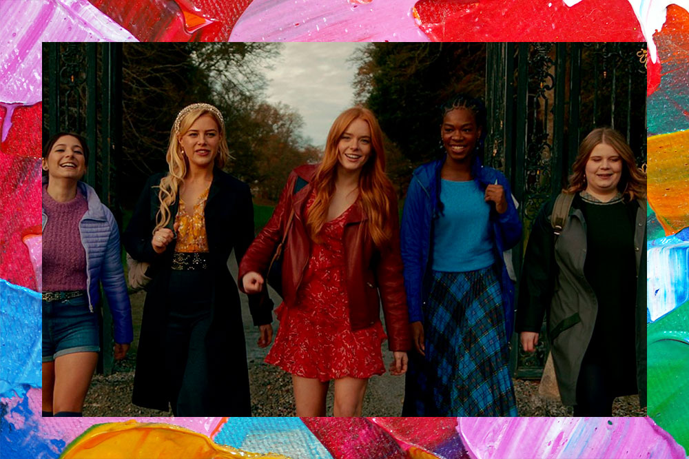 Imagem de divulgação de Fate: A Saga Winx com as cinco amigas alinhadas; elas estão andando e sorrindo em um caminho cheio de árvores