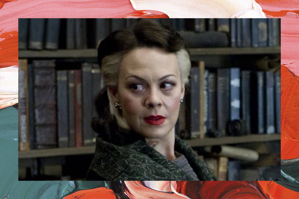 Helan McCrory como Narcisa Malfoy em Harry Potter, olhando de lado em frete a uma estante de livros