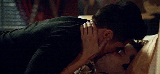 Os personagens Magnus e Alec, da série Shadowhunters, dando um beijo caliente na cama
