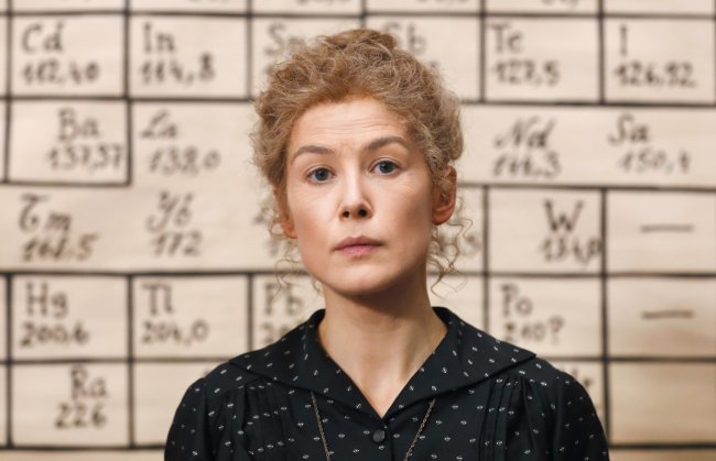 Radioactive: 10 coisas sobre Marie Curie que o filme da Netflix não conta Foto de divulgação do filme Radioactive, protagonizado por Rosamund Pike; a atriz está caracterizada em frente a uma lousa preenchida com elementos químicos