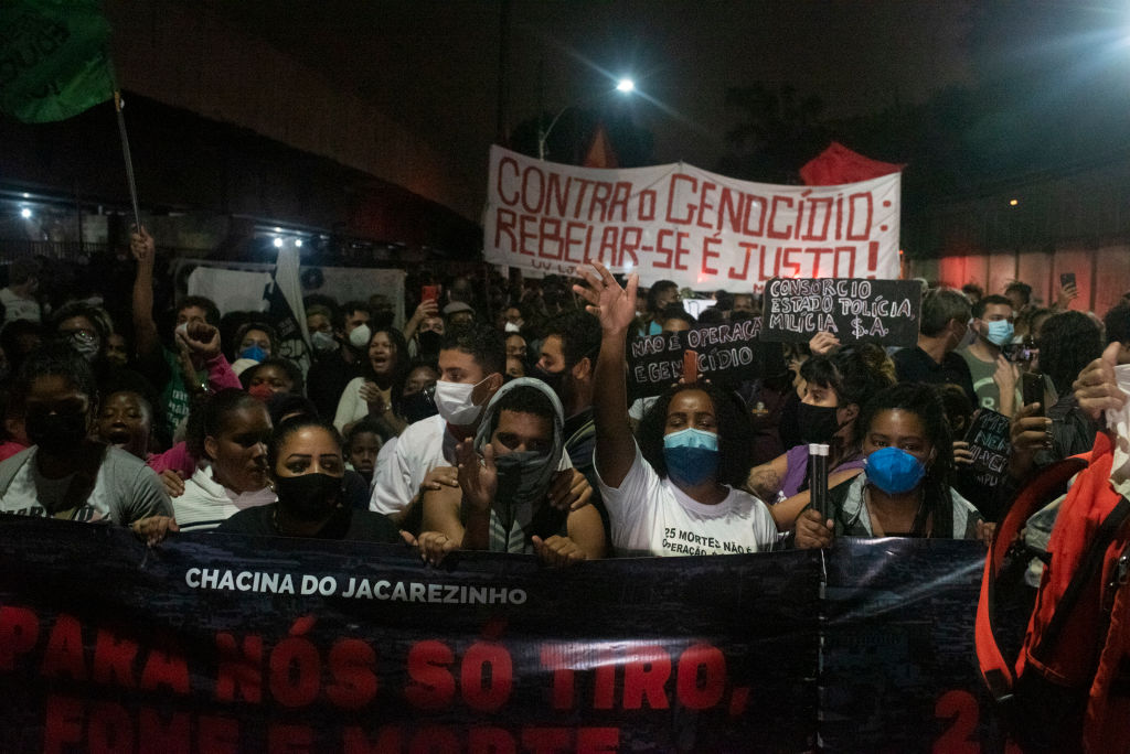 Moradores da favela do Jacarezinho protestam conta chacina e seguram faixas com os escritos: "Contra o genocídio, rebelar-se é justo"