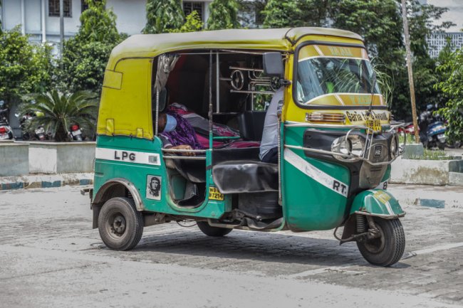 Paciente com COVID-19 sendo transportado em um tuk-tuk, devido à falta de ambulância, em Kolkata, na Índia