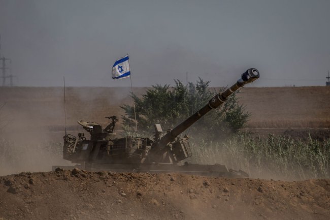 Um tanque de guerra com a bandeira de Israel aguarda no meio do nada, na fronteira entre Israel e Gaza