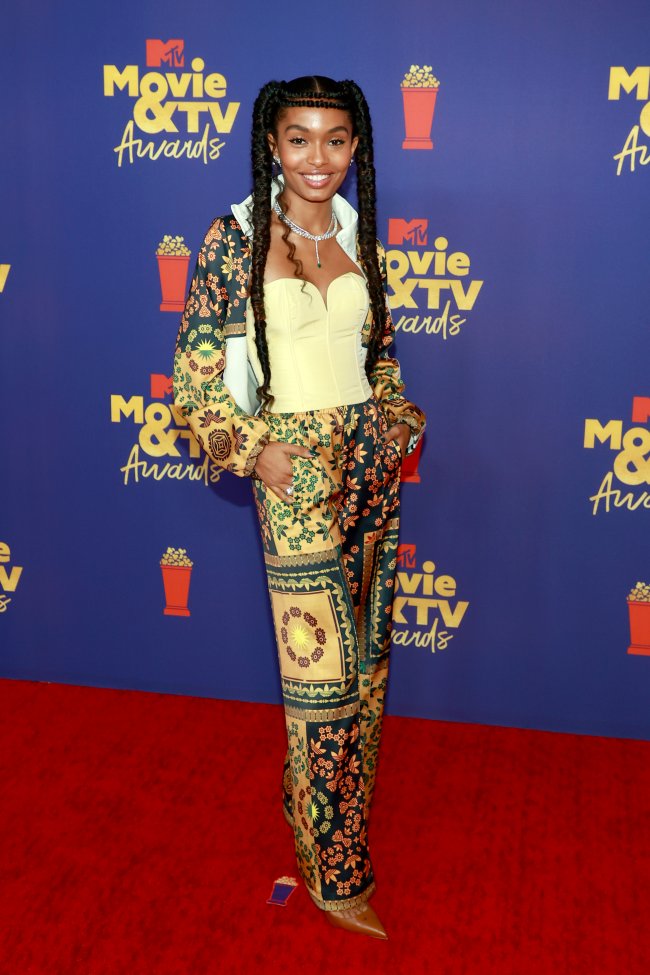 Atriz Yara Shahidi no MTV Movie & TV Awards Atriz Yara Shahidi no MTV Movie & TV Awards, usando corset amarelo e conjunto estampado, posando com expressão sorridente.
