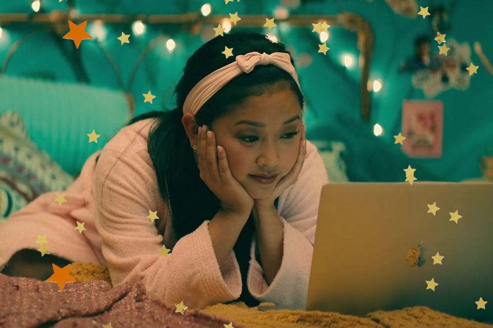 Lara Jean olhando com cara de contente, notebook