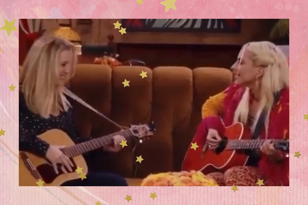 Lisa Kudrow e Lady Gaga cantam Smelly Cat na reunion de Friends; as duas estão se olhando enquanto tocam violão e cantam no sofá do Central Perk, cenário de Friends