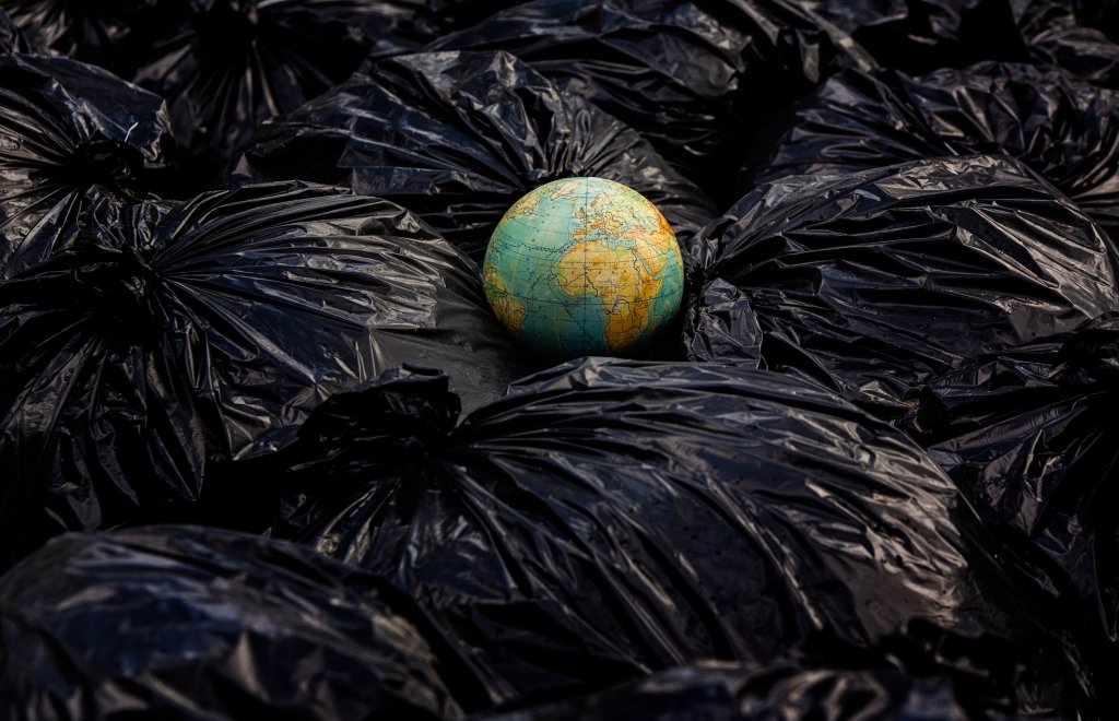 O Planeta Terra descartado no meio de um monte de sacos de lixo plástico