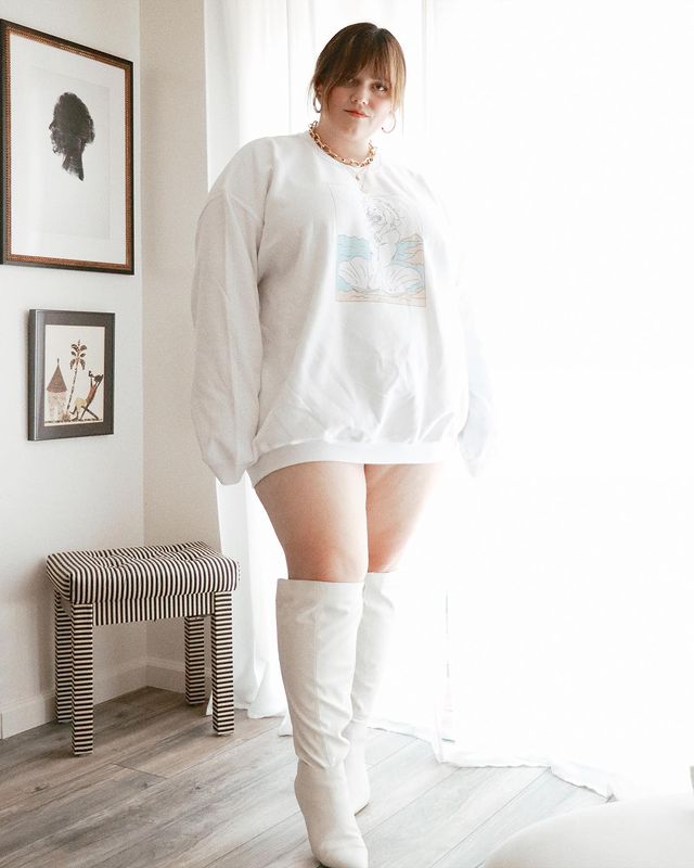 Garota usando blusa de moletom branca como vestido e bota branca na altura do joelho.