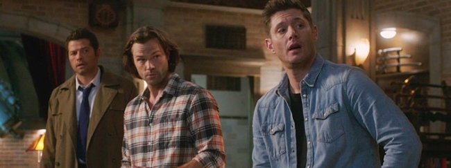 Dean e Sam Winchester e Castiel em Supernatural um ao lado do outro olhando em direção à direita