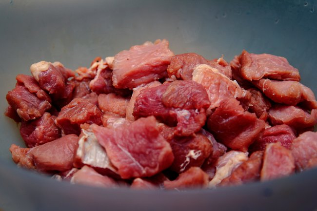 Tigela com uns pedaços de carne crua e vermelha cortados
